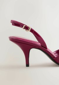 Sandale à talon haut en cuir verni fuchsia avec une fine bride à la cheville, bout ouvert et talon effilé ; elle présente une finition brillante et un design minimaliste.