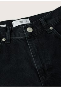 Jeans de denim negro con herrajes plateados, que presentan un diseño clásico de cinco bolsillos, costuras detalladas y una etiqueta de marca en el interior de la cintura.