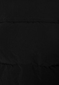 Černá péřová bunda z látky s texturovaným povrchem, s prošívanými horizontálními švy a lehkým, izolačním designem.