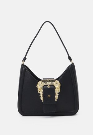 Black leather shoulder bag with a gold ornate buckle engraved with "Versace Jeans Couture" on a white background.