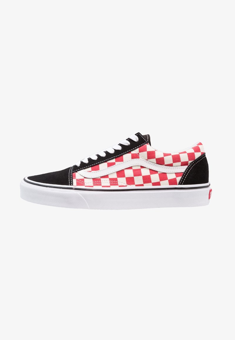 Basket basse avec motif à carreaux rouges et blancs, bout et talon noirs, lacets blancs et semelle blanche avec une bande noire.