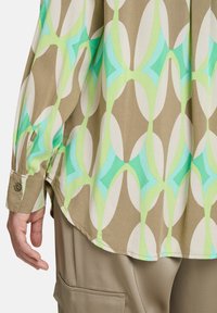 Camicia a fantasia con forme astratte in crema, verde e turchese, realizzata in tessuto leggero, con polsini a bottoni e una vestibilità rilassata.