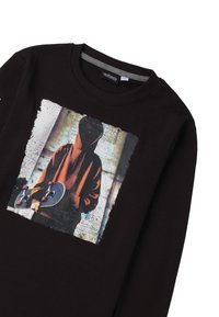 Zwarte long-sleeve t-shirt met een grafische print van een gehulde figuur die een skateboard vasthoudt, met een gestructureerde achtergrond in gedempte kleuren.