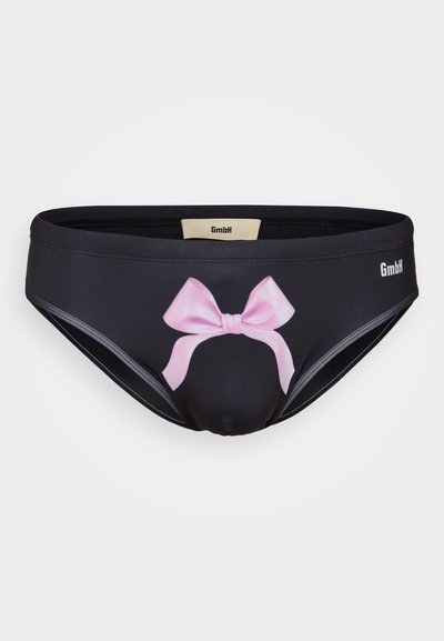 Bas de bikini noir avec un design de nœud rose à l'avant. Fabriqué en matériau lisse, il présente un logo GMBH et une bordure grise contrastante.