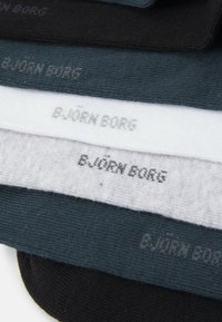 Egy pár zokni fekete, sötétszürke, világosszürke és fehér színben. Mindegyiken a "B.JÖRN BORG" logo kontrasztos színben található a szegélyen.