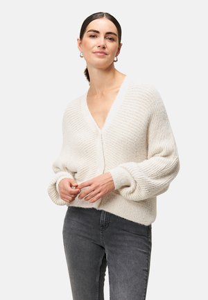 Crème-kleurige gebreide cardigan met een diepe V-hals, ballonmouwen en een relaxte pasvorm. Heeft een ribbelstructuur en een knoopsluiting aan de voorkant.