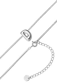 Srebrny naszyjnik z łańcuszka z zakrzywionym, błyszczącym wisiorkiem w kształcie litery "D". Zawiera regulowany zamek z okrągłą metalową zawieszką.