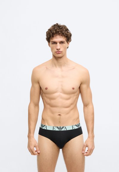 Cuecas masculinas pretas com um cós elástico em verde-água claro apresentando um logótipo. As cuecas têm uma textura suave e um design ajustado.