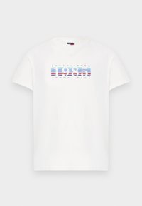 Λευκό κοντομάνικο T-shirt με την ένδειξη "1985" και "Tommy Jeans" πάνω σε φόντο μπλε και κόκκινες ρίγες στο στήθος.