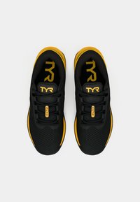 Czarne buty sportowe z żółtymi akcentami, siateczkowa cholewka, okrągły czubek i płaska podeszwa. Posiadają logo TYR na języku i boku.