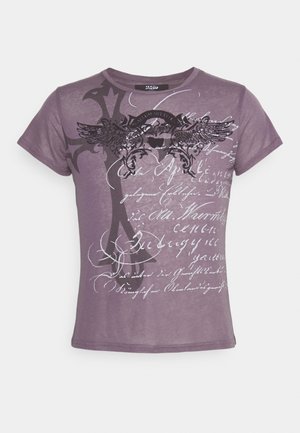 Camicia aderente viola a maniche corte con stemma alato, grande croce e testo bianco in caratteri stilizzati sul davanti.