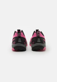 Sportschuhe mit einem pinken Obermaterial, schwarzen Akzenten und einer profilierten Gummisohle mit einem gerillten Muster. Die Rückansicht zeigt Markendetails.