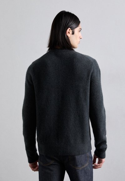 Pull en laine tricoté gris foncé, avec un col rond et des manches longues, présentant une texture douce et une coupe décontractée. Pas de motifs ni d'ornements visibles.