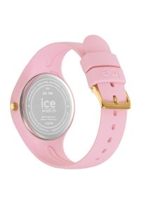 Montre en silicone rose avec un boîtier rond, des éléments en or et un bracelet texturé. L'arrière présente le logo de la marque et une résistance à l'eau de 10 ATM.