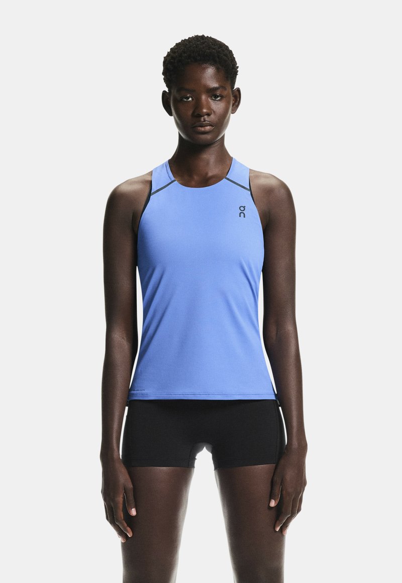 Débardeur de sport bleu avec un col rond, une coupe slim, et des accents noirs contrastants sur les bretelles, associé à un short noir. Texture lisse.