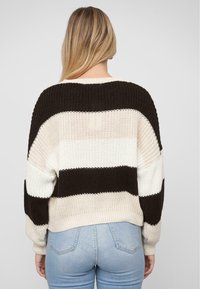 Strickpullover mit breiten horizontalen Streifen in Schwarz, Creme und Hellrosa, mit lockerem Schnitt und gerippten Bündchen und Saum.