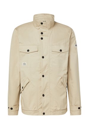 Beżowa lekka kurtka z wysokim kołnierzem, czarnymi zatrzaskami i czterema przednimi kieszeniami, dwie z klapkami, odpowiednia do codziennego noszenia.