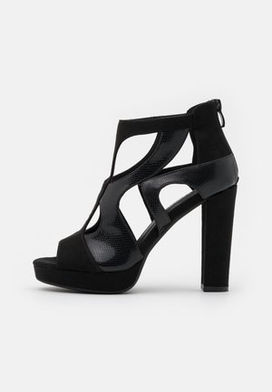 Czarna szpilka wykonana z połączenia zamszu i błyszczącej siateczki, z wycięciami, odkrytymi palcami oraz platformą.