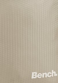 Beige textured material with a hexagonal pattern, featuring the word "Bench." in white letters at the bottom right corner.