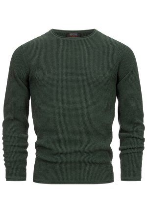 Tamnozeleni džemper od waffle pletenine s okruglim izrezom, dugim rukavima i rebrastim manžetama. Tkanina ima teksturirani završetak.