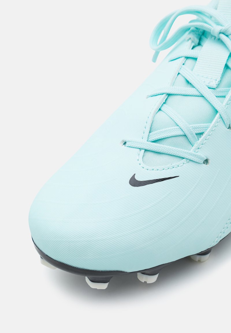 Botín de fútbol azul claro con upper sintético texturizado, logotipo negro de Nike y tacos blancos sobre una suela oscura. Presenta un diseño de cordones.