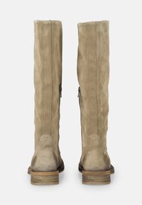 Botas de ante beige hasta la rodilla con una textura suave, que cuentan con una cremallera en la parte trasera y un tacón de madera apilada. Con costuras sutiles que las adornan.