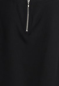 Gonna nera con chiusura frontale a cerniera argentata. Realizzata in un tessuto morbido, ha una forma sartoriale e una sottile texture.