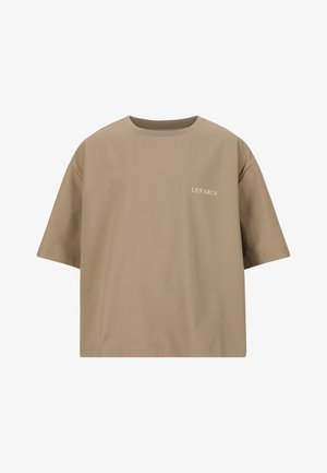 Lysebrunt cropped t-shirt med korte ærmer og hvid tekst foran, parret med sorte, løse bukser og sorte sneakers.