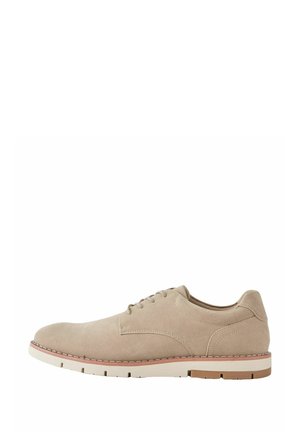 Beige suede men's lace-up shoe with white and brown rubber sole, visible stitching, and minimalist design shown in side profile.