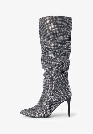 Luźne, wysokie kozaki do kolan z czarnej fakturowanej tkaniny z metalicznymi akcentami. Spiczasty nosek i obcas typu stiletto. Elastyczne dopasowanie z marszczonym wzorem.