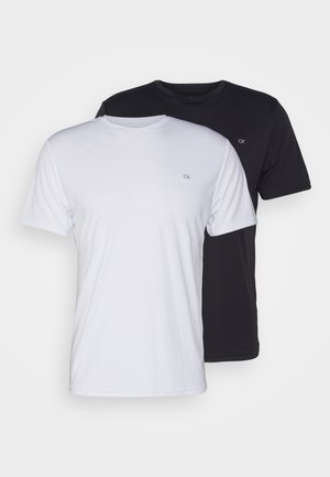 Two cotton t-shirts in white and black, short-sleeved with round necks, featuring a small logo on the chest, smooth texture.