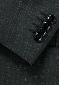 Black textured fabric with subtle light stripes; features a cuff with four glossy black buttons and stitched detailing.