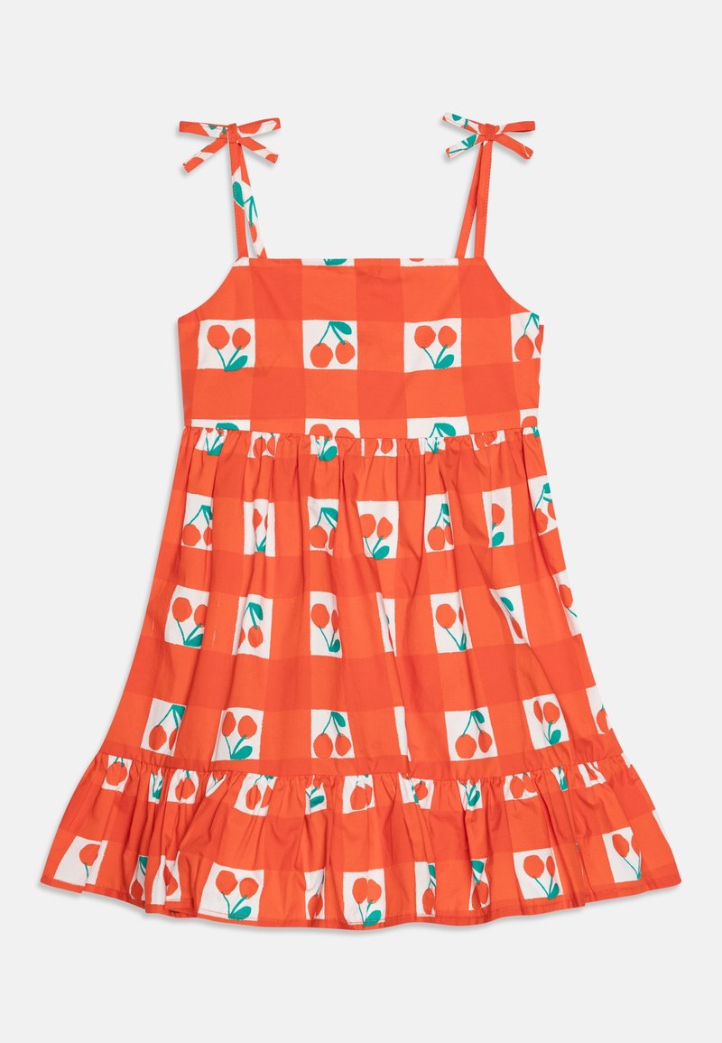 Robe à carreaux rouges avec des motifs de cerises. Dispose de fines bretelles ajustables et d'un ourlet volanté. Fabriquée en tissu léger.
