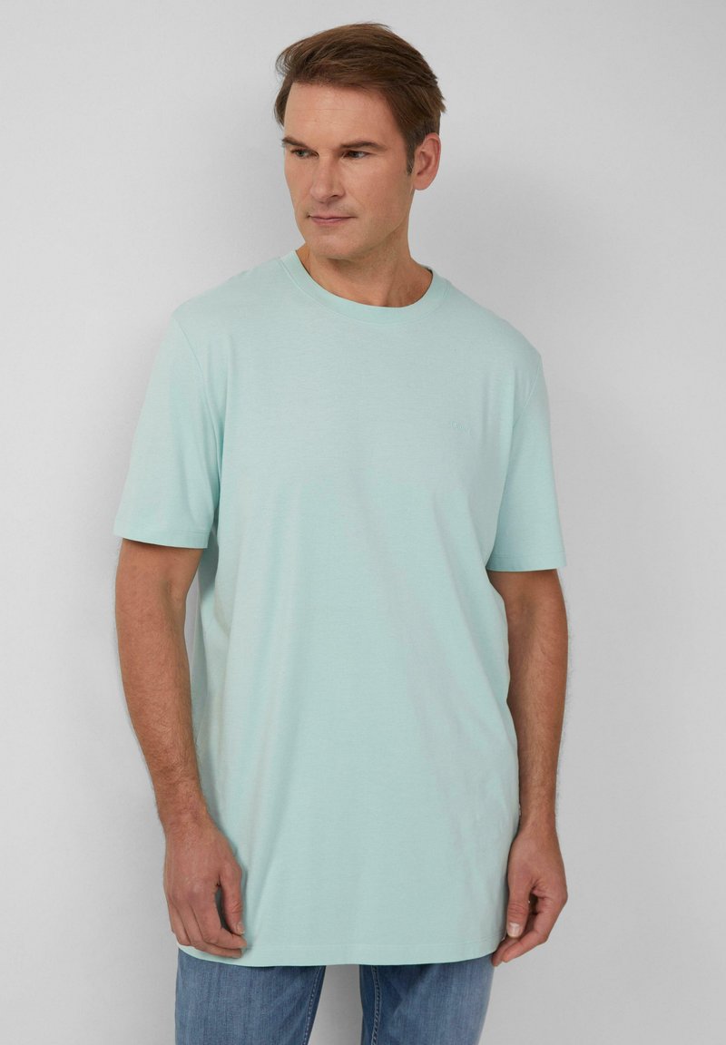 Helles mintgrünes T-Shirt aus weichem Material, mit klassischem Rundhalsausschnitt, kurzen Ärmeln und lockerer Passform, ergänzt durch dezente Markenkennzeichnung.