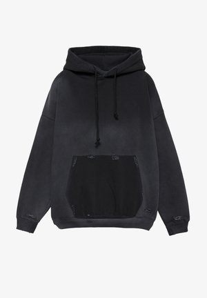 Čierna vypraná mikina s kapucňou, predným klokankovým vreckom a malými ošúchanými dierkami na vrecku, manžetách a spodnom okraji, s kapucňou na sťahovanie.