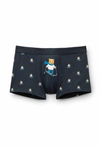 Boxerské trenýrky z tmavě modré látky, zdobené opakovaným vzorem lyžařského medvěda v modrém šále. Měkký, pružný materiál s elastickým pasem.