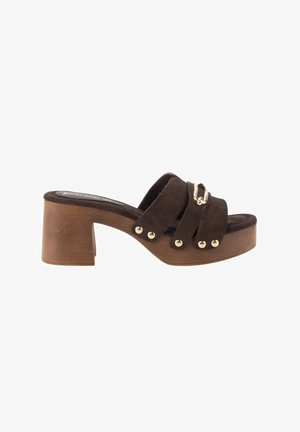 Mule de ante marrón con punta abierta, tacón bloque de madera, tres tiras aseguradas con remaches dorados y una pequeña hebilla dorada decorativa en la tira superior.