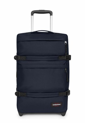 Maleta vertical azul marino con ruedas, asa extensible, dos correas horizontales de compresión, bolsillo frontal con cremallera y parche con el logo de Eastpak.