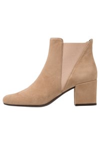 Beige mockask stövlett med spetsig tå, elastiska sidopaneler och en kraftig klack, med en slät textur och minimala sömmar.