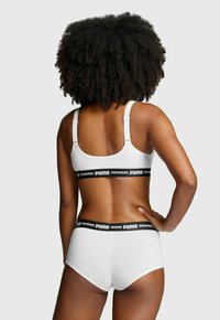 Weißes Baumwoll-BH- und Slips-Set mit schwarzen Puma-Logo-Bändern. Der BH hat verstellbare Träger und eine glatte Oberfläche.