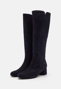 Botas de ante azul marino hasta la rodilla, con punta redonda, tacón cuadrado y una silueta elegante. Sin herrajes ni patrones visibles. Textura suave.