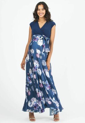 Abito avvolto per maternità in blu navy con maniche corte, stampa floreale in viola e bianco, e dettaglio con fiocco laterale. Tessuto morbido e fluido, lunghezza alla caviglia.