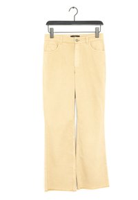 Jeans beige a zampa d'elefante in cotone. Presentano tasche frontali, chiusura con zip e orlo sfilacciato. Texture liscia con una finitura leggermente sfumata.