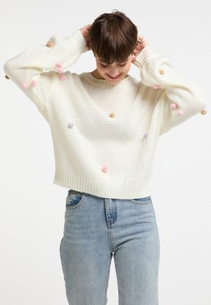Pull en tricot blanc avec un design court, orné de pompons colorés en violet, rose et beige sur le corps et les manches.