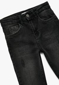 Mustat farkut, jotka tarjoavat slim fit -istuvuuden, klassisen viiden taskun muotoilun ja etuosassa kuluneet yksityiskohdat. Viimeistelty nappikiinnityksellä.