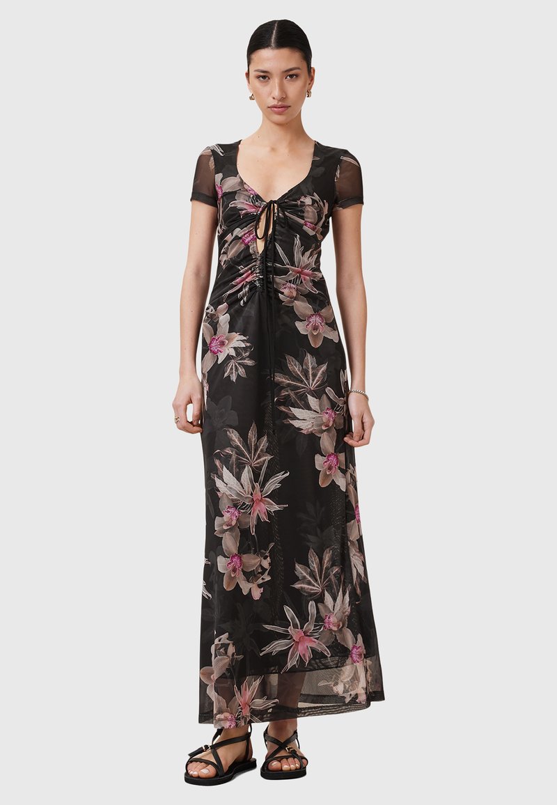 Maxi-jurk met korte mesh-mouwen, bloemenpatroon in roze en crèmekleur op een zwarte achtergrond, gathered detail bij de halslijn en een sleutelgatopening aan de voorkant.
