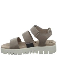 Brown leather sandals with three wide straps and a cushioned footbed. Chunky white rubber sole with a serrated edge for traction.