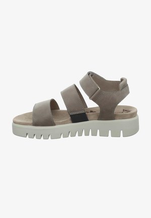 Brown leather sandals with three wide straps and a cushioned footbed. Chunky white rubber sole with a serrated edge for traction.