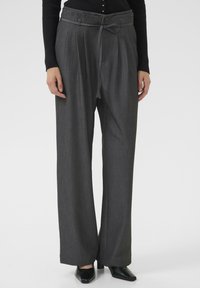 Grijze wijde broek met plooien, riemlussen en een bijpassende strikceintuur. Gemaakt van een zachte, gestructureerde stof, met een pasvorm die zorgvuldig is afgekapt en strakke lijnen.