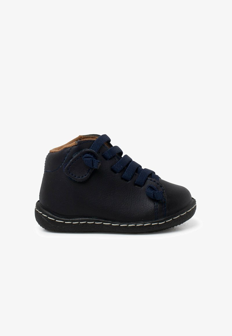 Scarpa nera in pelle con lacci blu navy e suola bianca cucita. Presenta una punta arrotondata e una soffice fodera color cammello alla caviglia.